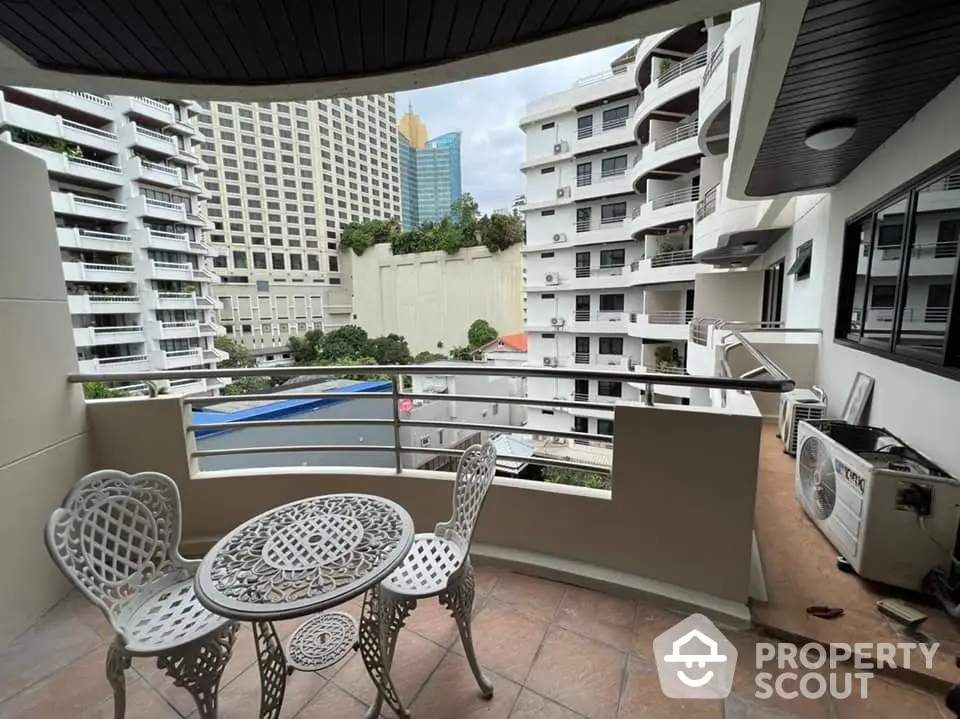 Spacious balcony with city view, perfect for relaxation and outdoor dining in urban setting.