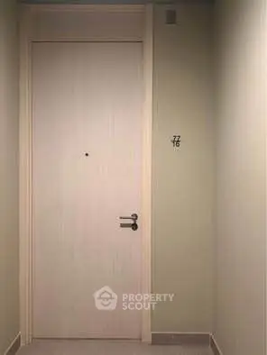 Modern apartment entrance with sleek door design and neutral tones.