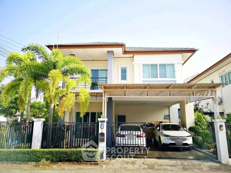 Modern two-story house with carport and lush greenery in a suburban neighborhood.