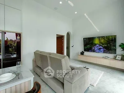 Modern living room with sleek furniture and large TV, perfect for relaxation and entertainment.