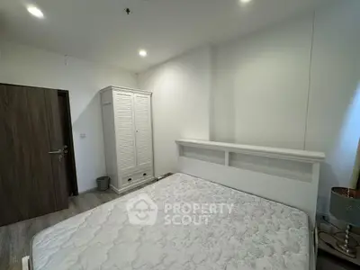 Spacious bedroom with modern white furniture and cozy ambiance