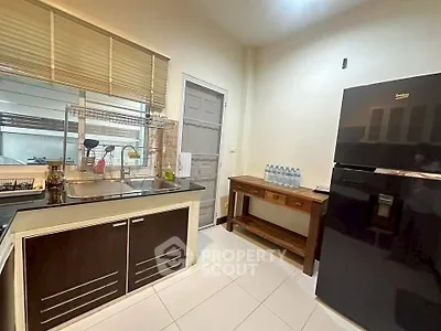 Modern kitchen with sleek black fridge and ample counter space in a cozy home setting.