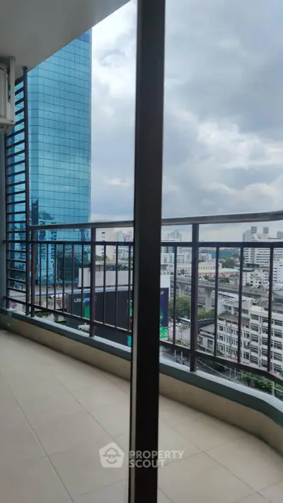 Spacious balcony with stunning city view in modern high-rise building.