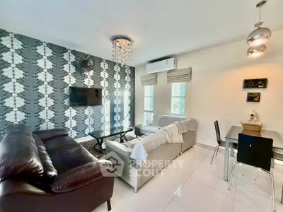 Stylish living room with modern decor and dining area, featuring chic wallpaper and elegant lighting.