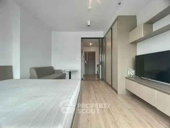 Modern bedroom with sleek design, featuring a comfortable bed, built-in wardrobe, and wall-mounted TV for ultimate relaxation.