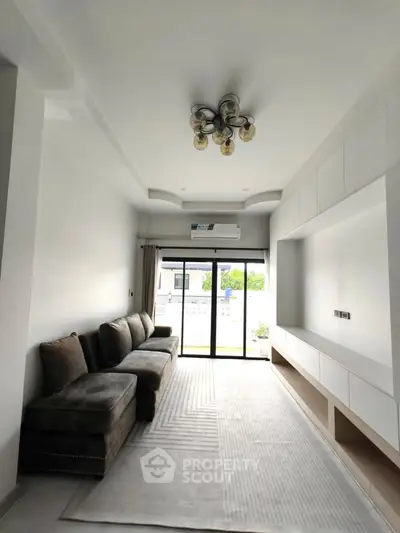 Spacious modern living room with elegant lighting and large windows for natural light.