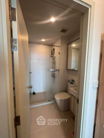 Modern bathroom with glass shower and sleek fixtures in a contemporary apartment.