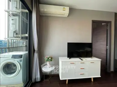 Modern living room with TV, air conditioner, and washing machine on balcony.
