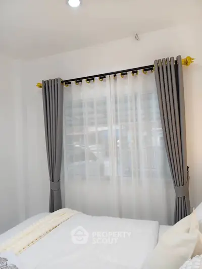 Cozy bedroom with elegant curtains and soft bedding