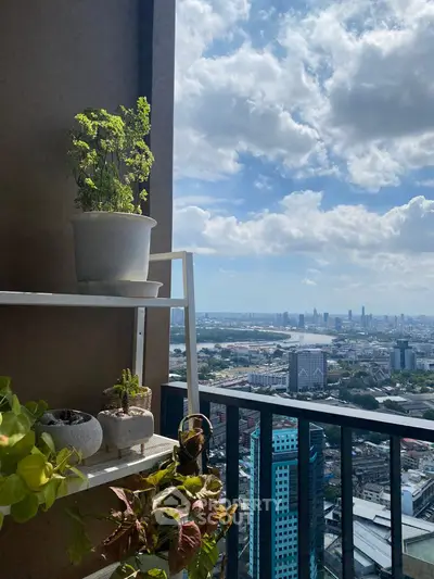 Stunning high-rise balcony view with lush plants and cityscape backdrop under a vibrant sky.