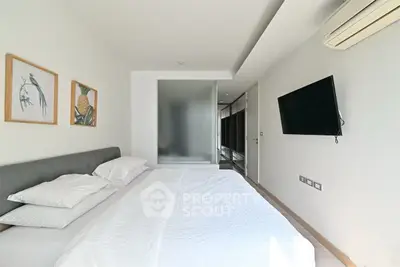 Modern bedroom with minimalist decor, featuring a wall-mounted TV and air conditioning unit.