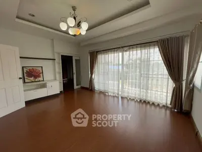 Spacious living room with elegant lighting and large windows offering natural light.