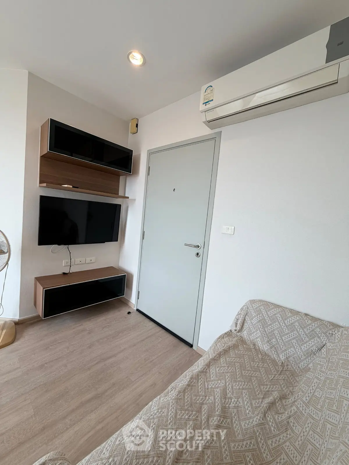 Modern living room with sleek TV setup and air conditioning, perfect for cozy relaxation.