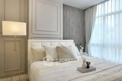 Elegant bedroom with modern decor and large window for natural light.