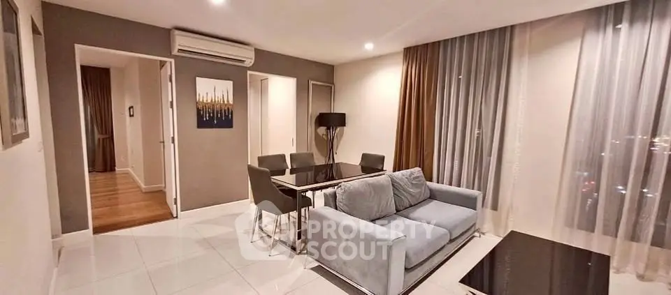 Modern living room with sleek furniture and large windows in a stylish apartment.