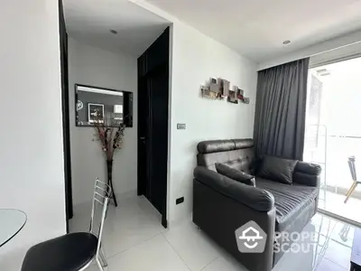 Modern living room with sleek leather sofa, tiled floors, and tasteful decor leading to a sunlit balcony, perfect for urban living.