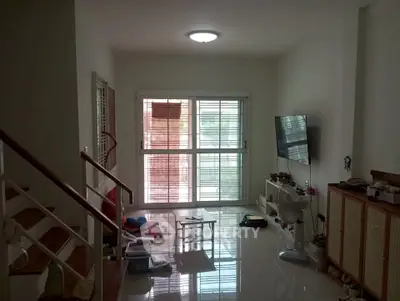 Spacious living room with modern decor and large window, perfect for family gatherings.