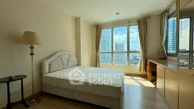 Bright bedroom with city view, large windows, and modern furnishings.