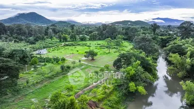 Scenic aerial view of lush green landscape with river and distant mountains, perfect for nature lovers.
