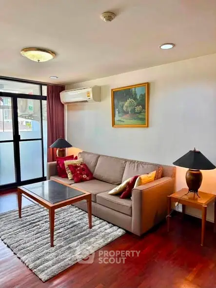 Charming living room with cozy sofa, elegant decor, and natural light from large windows.