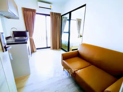 Modern apartment with open layout, featuring a cozy living area and sleek kitchen design.