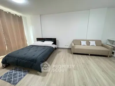 Spacious bedroom with modern decor and cozy seating area, perfect for relaxation and comfort.