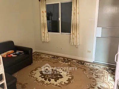 Cozy living room with patterned rug and sofa, ideal for relaxation.