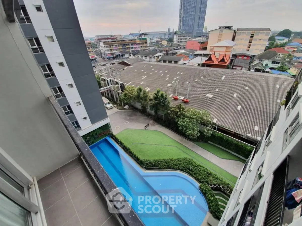 Stunning high-rise view with pool and cityscape from a modern balcony.