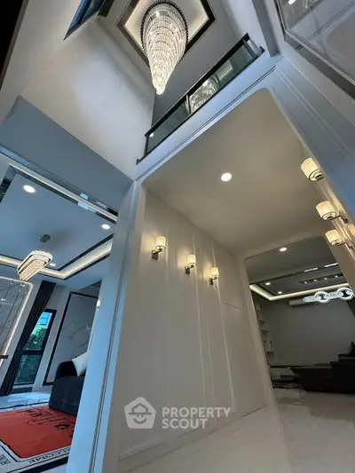 Luxurious modern interior with high ceilings and elegant chandeliers in a spacious living area.