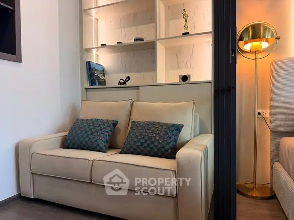 Cozy living room corner with a stylish sofa and modern lighting, perfect for relaxation and reading.