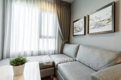 Modern living room with cozy gray sofa and elegant decor in a bright apartment.