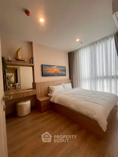 Modern bedroom with wooden flooring, large window, and stylish decor