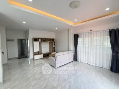 Spacious modern living room with elegant marble flooring and stylish ceiling lights.