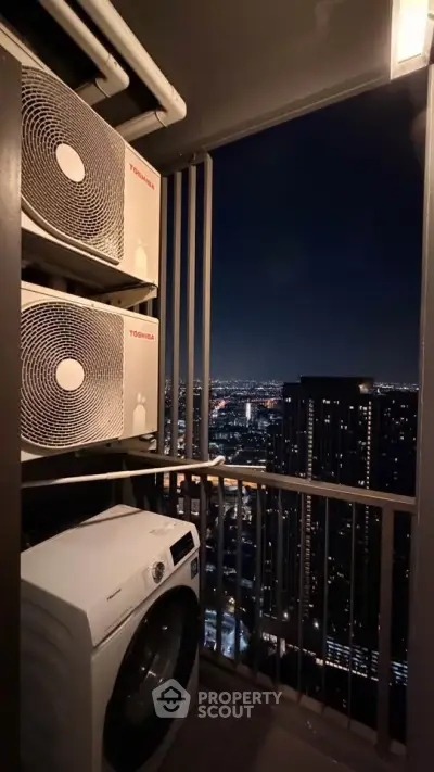 Stunning high-rise balcony with city view and modern appliances at night.