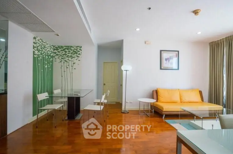Modern living room with stylish decor and wooden flooring, featuring a cozy sofa and dining area.