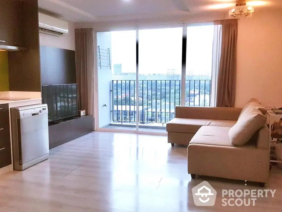 Spacious living room with modern decor and stunning balcony view in a high-rise apartment.