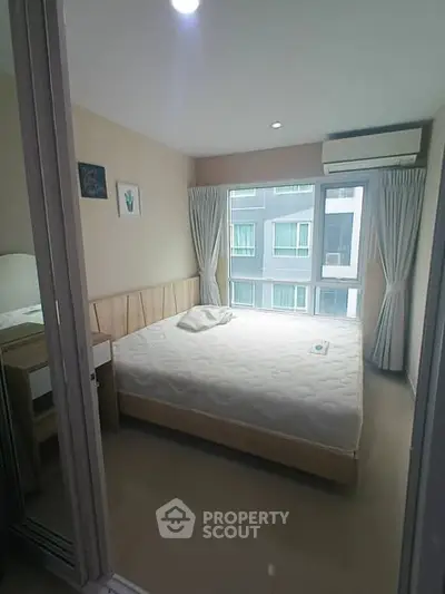 Cozy bedroom with large window and modern decor in urban apartment