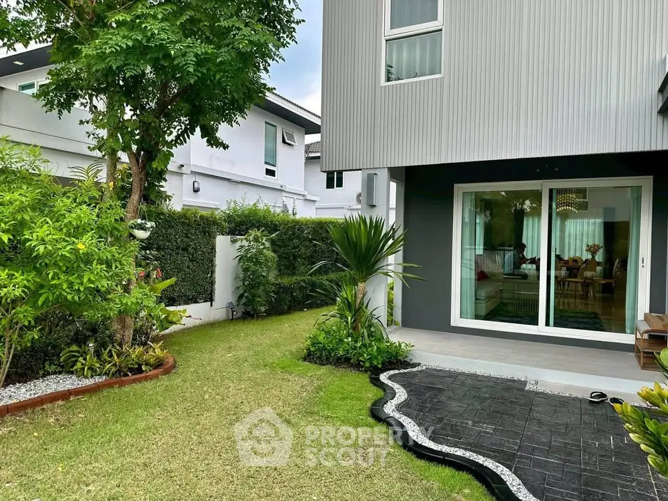 Modern home with lush garden and stylish patio, perfect for outdoor relaxation and entertaining.