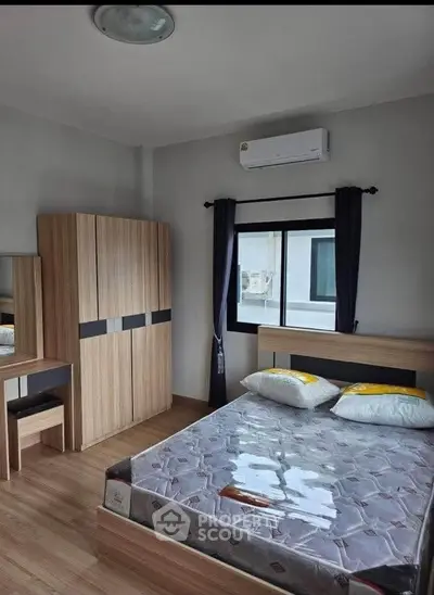 Modern bedroom with wooden furniture and air conditioning in a cozy apartment.