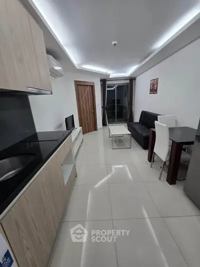 Modern living room with sleek kitchen and stylish furniture in a contemporary apartment.