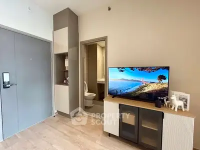 Modern living room with TV and open bathroom door, stylish decor