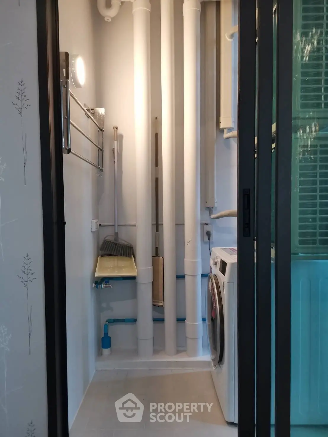 Compact laundry area with washing machine and storage space in modern apartment.