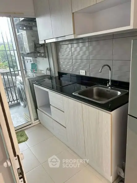 Modern kitchen with sleek cabinetry and balcony access
