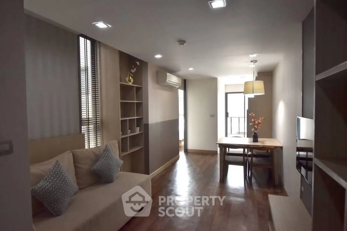 Modern living room with wooden flooring and stylish dining area in a cozy apartment.