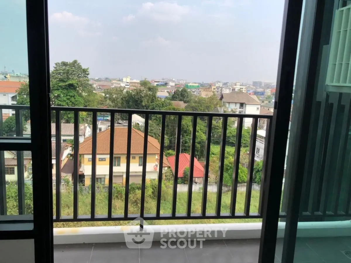 Stunning balcony view overlooking a vibrant cityscape with lush greenery and urban charm.