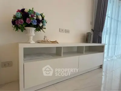 Modern living room with elegant white TV stand and floral decor