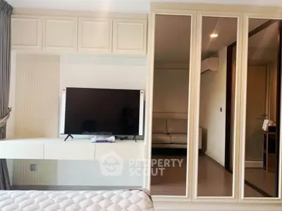 Modern bedroom with mirrored wardrobe and sleek TV setup