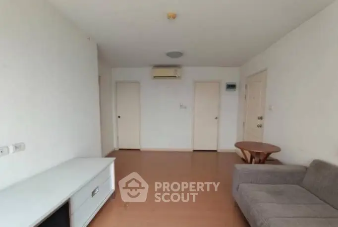 Spacious living room with modern furniture and air conditioning in a minimalist apartment.