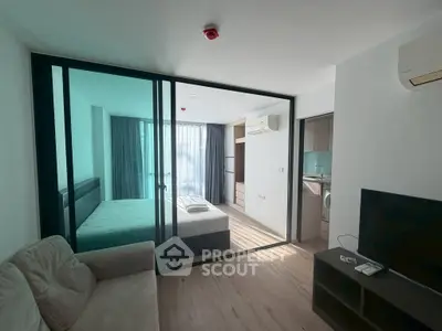 Modern studio apartment with glass partition, cozy living area, and natural light