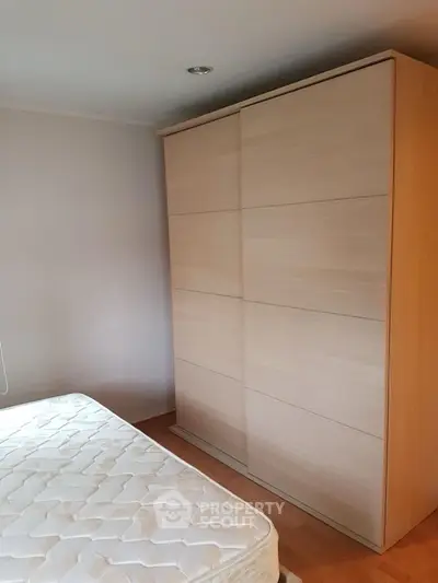 Spacious bedroom with modern wardrobe and comfortable mattress